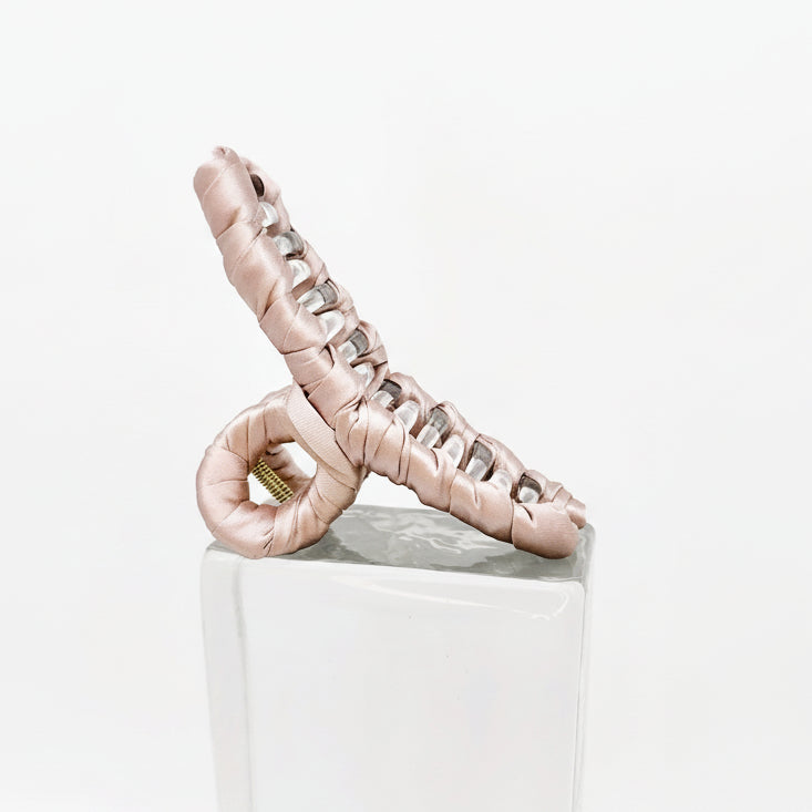 rosé Klammer auf Glasklotz vor weißem Hintergrund