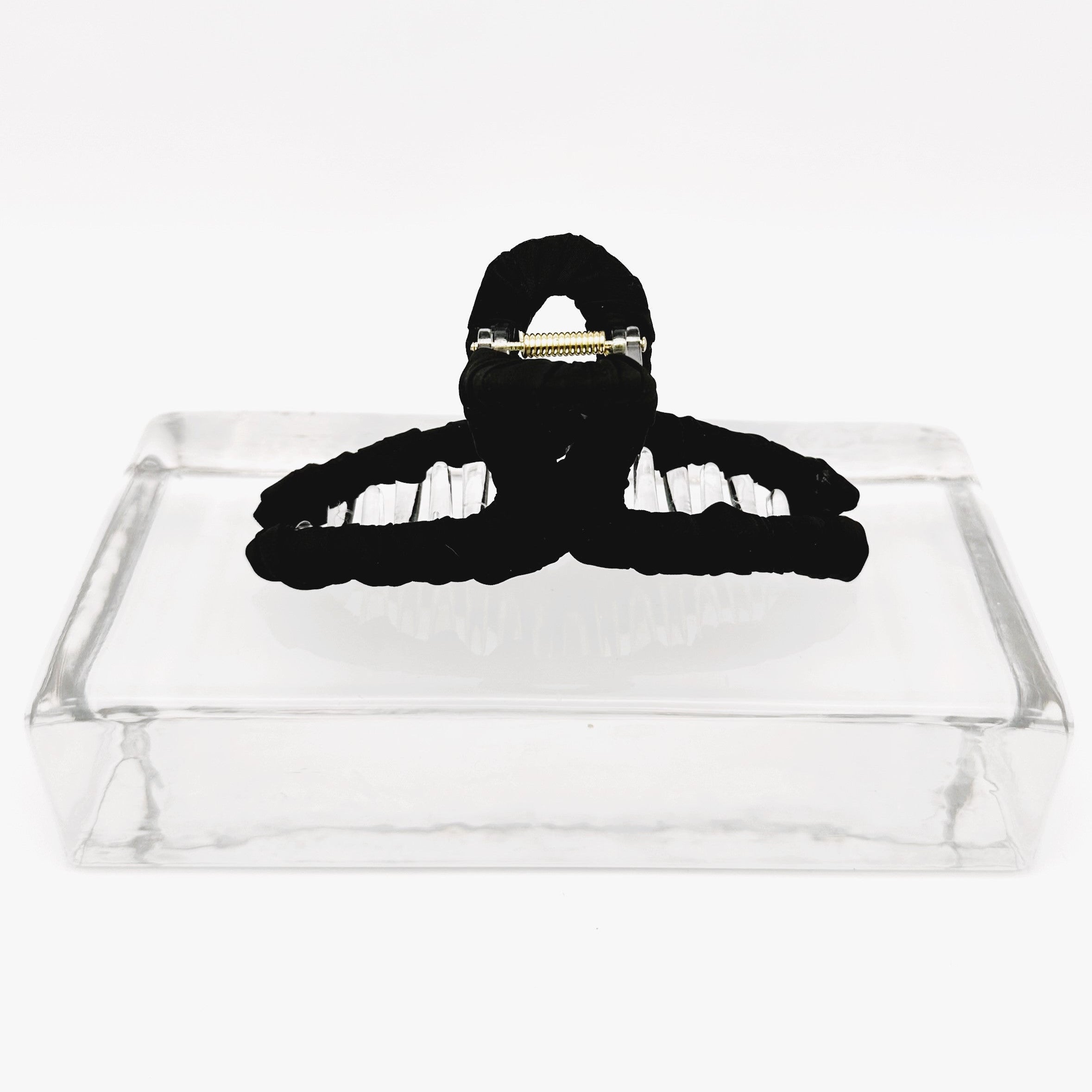 schwarze Haarklammer auf Glasklotz